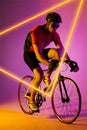 Caucasian male athlete wearing helmet and eyewear riding bike by illuminated triangle, copy space