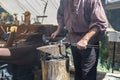 Caucasian male blacksmith forges iron in an anvil. Royalty Free Stock Photo