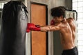 Boxer workout and training boxing by punching with sand bag in gym