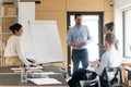 Caucasian male coach make whiteboard presentation to diverse employees Royalty Free Stock Photo