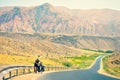 Caucasian male cyclist push his heavy touring bicycle uphill in extreme heat outdoors in mountains. Bicycle touring adventure Royalty Free Stock Photo