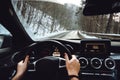 Male driving on forest road during wintertime. Snow and wet roads concept Royalty Free Stock Photo