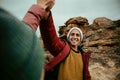 Caucasian male hiker high five female after pitching tent on top of mountain