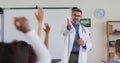 Caucasian male medical worker wearing sthetoscope, standing in classroom asking questions