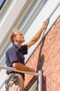 Caucasian male painter cleaning roof molding with cloth