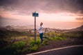 Caucasian male posing at the signpost on Camino Las Hoyas road in Tenerife, Spain under a cloudy sky