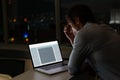 Caucasian male programmer sitting at desk, using laptop with coding on screen Royalty Free Stock Photo
