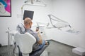 Caucasian male is taking selfie in a dental chair in a hospital