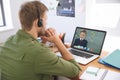 Caucasian male teacher using laptop and phone headset on video call with schoolboy learning from hom Royalty Free Stock Photo