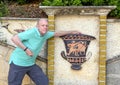 Caucasian male tourist by decorated wall in the parking lot just past the front of the Jewish Cemetary, Castle Hill Park, Nice