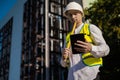 Caucasian male worker at a construction site. Architectural design is holding a laptop at a construction site, checking plans.