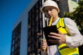 Caucasian male worker at a construction site. Architectural design is holding a laptop at a construction site, checking plans.