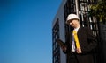 Caucasian male worker at a construction site. Architectural design is holding a laptop at a construction site, checking plans.