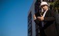 Caucasian male worker at a construction site. Architectural design is holding a laptop at a construction site, checking plans.