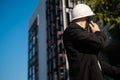 Caucasian male worker at a construction site. Architectural design is holding a laptop at a construction site, checking plans.