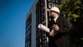 Caucasian male worker at a construction site. Architectural design is holding a laptop at a construction site, checking plans.