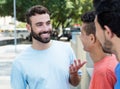 Caucasian man with beard talking with two friends in the city Royalty Free Stock Photo