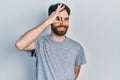 Caucasian man with beard wearing casual grey t shirt doing ok gesture with hand smiling, eye looking through fingers with happy Royalty Free Stock Photo