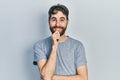 Caucasian man with beard wearing casual grey t shirt looking confident at the camera with smile with crossed arms and hand raised Royalty Free Stock Photo