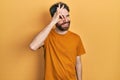 Caucasian man with beard wearing casual yellow t shirt doing ok gesture with hand smiling, eye looking through fingers with happy Royalty Free Stock Photo