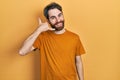 Caucasian man with beard wearing casual yellow t shirt smiling doing phone gesture with hand and fingers like talking on the Royalty Free Stock Photo