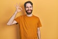 Caucasian man with beard wearing casual yellow t shirt smiling positive doing ok sign with hand and fingers Royalty Free Stock Photo