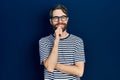 Caucasian man with beard wearing striped t shirt and glasses looking confident at the camera with smile with crossed arms and hand Royalty Free Stock Photo