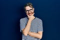 Caucasian man with beard wearing striped t shirt and glasses looking confident at the camera smiling with crossed arms and hand Royalty Free Stock Photo