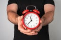 Caucasian man holding vintage red alarm clock in his hands Royalty Free Stock Photo