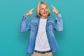 Caucasian man with blond long hair wearing casual denim jacket smiling pointing to head with both hands finger, great idea or