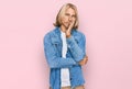 Caucasian man with blond long hair wearing casual denim jacket thinking looking tired and bored with depression problems with