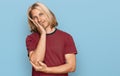 Caucasian man with blond long hair wearing casual striped t shirt thinking looking tired and bored with depression problems with