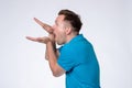 Caucasian man in blue shirt making bla bla sign with his hand