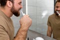 Side view on caucasian man brushing teeth with electric toothbrush during morning hygiene Royalty Free Stock Photo