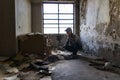 Caucasian man in cap and hood phone with broken phone in abandoned building. Hacker, racketeer, terrorist concept