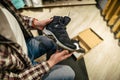 Caucasian man chooses and measures hiking boots at a sports and travel store. Man looking at hiking shoes in outdoor