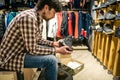 Caucasian man chooses and measures hiking boots at a sports and travel store. Man looking at hiking shoes in outdoor