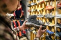 Caucasian man chooses and measures hiking boots at a sports and travel store. Man looking at hiking shoes in outdoor