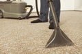 Man in service cleaning carpet on floor with wet and dry vacuum cleaner