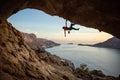 Caucasian man climbing challenging route in cave at sunset Royalty Free Stock Photo