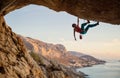 Caucasian man climbing challenging route going along ceiling in cave at sunset Royalty Free Stock Photo