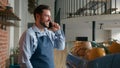 Caucasian man coffee shop employee in apron talk on mobile phone behind cafeteria counter professional barista waiter Royalty Free Stock Photo