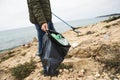 Man collects garbage with a reach extender