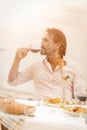 Caucasian man drinks luxury wine outdoor. Profile view of attractive middle-aged man enjoying wonderful beverage while Royalty Free Stock Photo