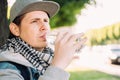 Caucasian man drinks mineral water from a plastic bottle