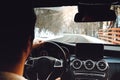 Caucasian man driving car on the empty road, winter and snow background Royalty Free Stock Photo