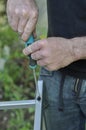 Caucasian man fixing ladders with screw driver on his free time. Closeup of old wrinkled hands. Outdoor activity in summer Royalty Free Stock Photo