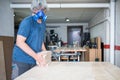 Caucasian man fond of working with wood holds pieces of wood in his small workshop Royalty Free Stock Photo