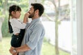 Caucasian man fun to play with his daughter in room with glass windows and they look happy to stay at home during pandemic of Royalty Free Stock Photo