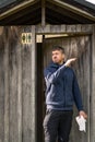 Caucasian man going out rustic outdoors toilet with toilet paper in his hand and smelling bad Royalty Free Stock Photo